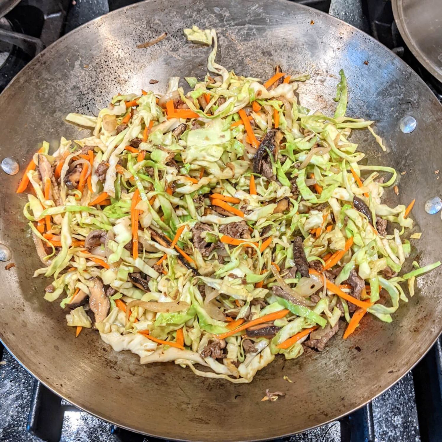 Meat, Cabbage, and Carrots Added to the Stir Fry